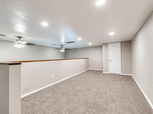 basement featuring ceiling fan and carpet flooring