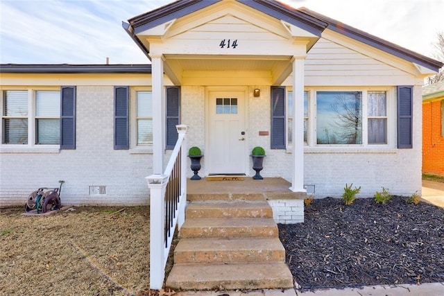 doorway to property with crawl space and brick siding