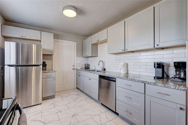 414 NW 50th St, Oklahoma City, OK 73118 - kitchen featuring stainless steel appliances, light marble finish flooring, a sink, light stone counters, and gray cabinets