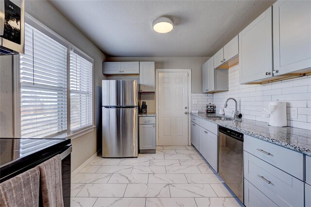 414 NW 50th St, Oklahoma City, OK 73118 - kitchen with appliances with stainless steel finishes, light marble finish flooring, a sink, light stone countertops, and tasteful backsplash