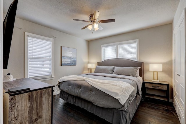 414 NW 50th St, Oklahoma City, OK 73118 - bedroom featuring dark wood-style floors, baseboards, a textured ceiling, and a ceiling fan