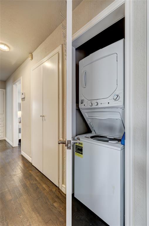414 NW 50th St, Oklahoma City, OK 73118 - clothes washing area featuring stacked washer / dryer, dark wood-style floors, and baseboards