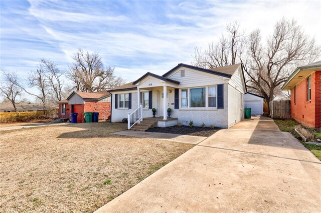 414 NW 50th St, Oklahoma City, OK 73118 - bungalow featuring brick siding, a detached garage, an outbuilding, and fence