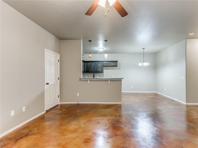 unfurnished living room with ceiling fan with notable chandelier