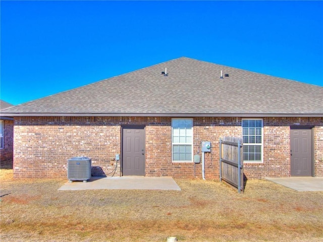 rear view of house with a patio, a lawn, and central air condition unit