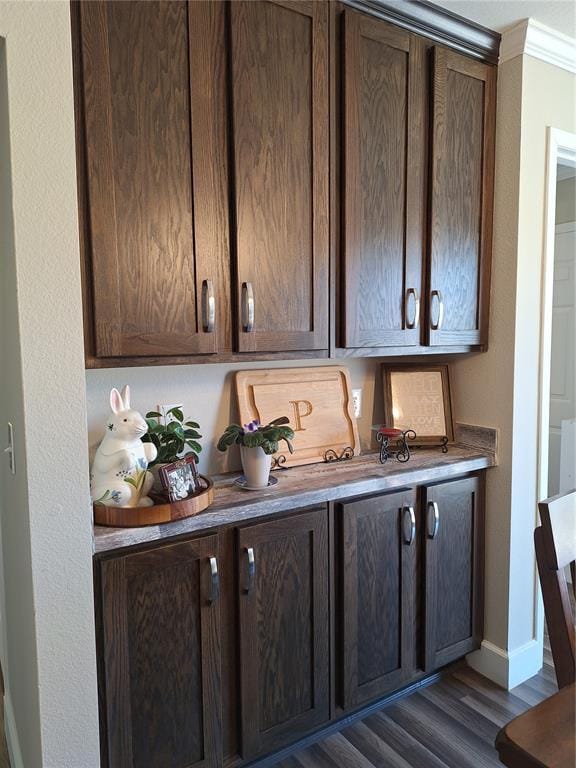 bar featuring ornamental molding, dark wood finished floors, and baseboards