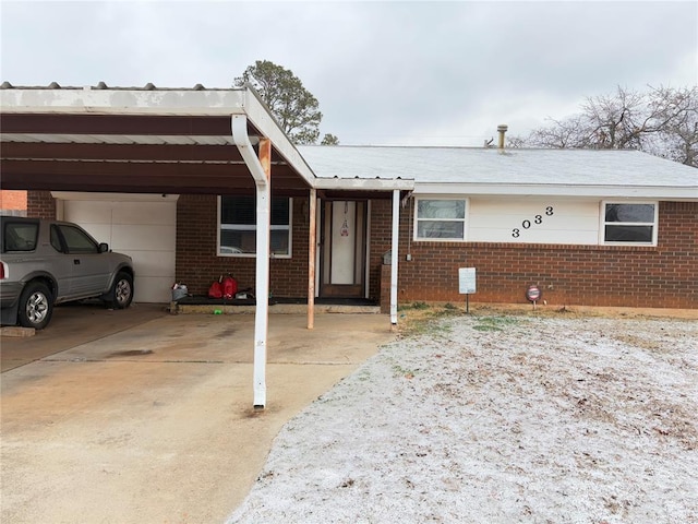 ranch-style house with an attached carport, concrete driveway, and brick siding