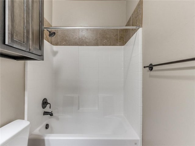 bathroom featuring bathtub / shower combination and toilet