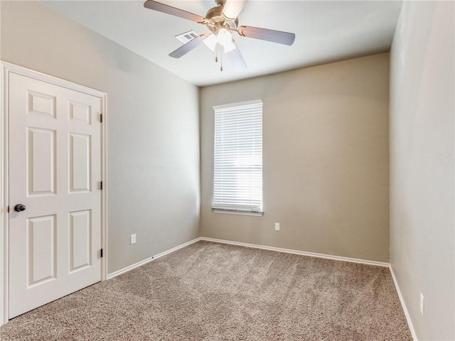 carpeted spare room with ceiling fan