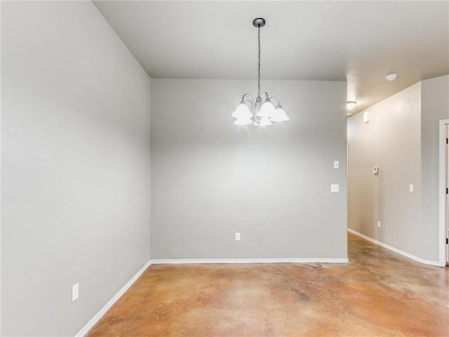 empty room with concrete flooring and a notable chandelier