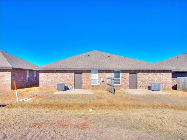 rear view of property featuring a patio, a yard, and central air condition unit