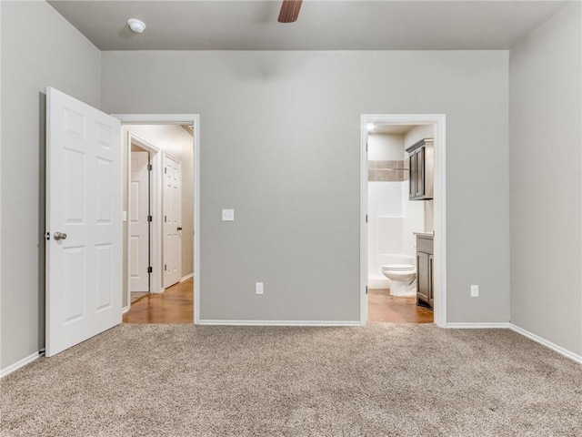 unfurnished bedroom with light carpet, ensuite bathroom, and ceiling fan