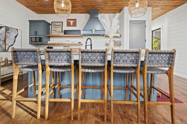 kitchen featuring wooden ceiling, stainless steel microwave, dark wood finished floors, and open shelves