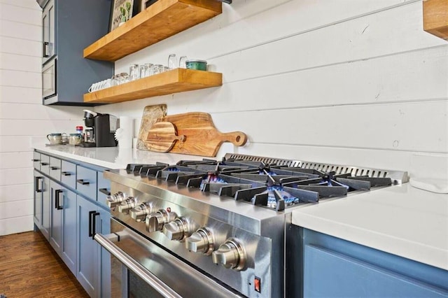 room details featuring light countertops, blue cabinetry, open shelves, and stainless steel stove