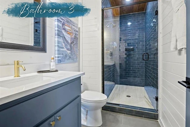 bathroom featuring toilet, tile patterned flooring, vanity, and a shower stall
