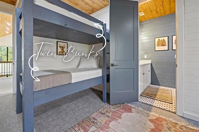interior space with wood walls, wood ceiling, and dark carpet