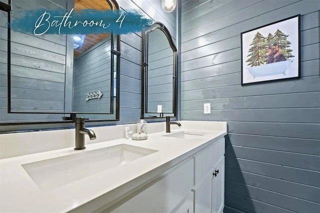 bathroom featuring double vanity, wood walls, and a sink
