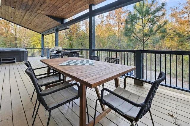 wooden terrace with a hot tub, grilling area, and outdoor dining area