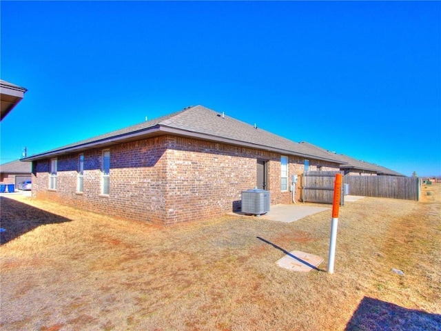 view of side of property with a patio area and central AC