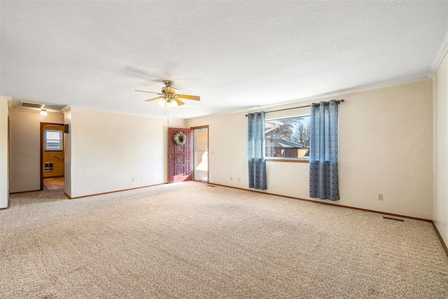 carpeted empty room with ornamental molding, ceiling fan, and a textured ceiling