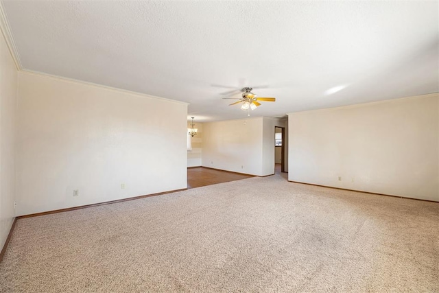 carpeted empty room featuring ornamental molding, ceiling fan with notable chandelier, and a textured ceiling