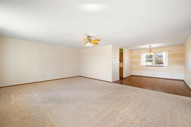 carpeted empty room featuring crown molding and ceiling fan with notable chandelier