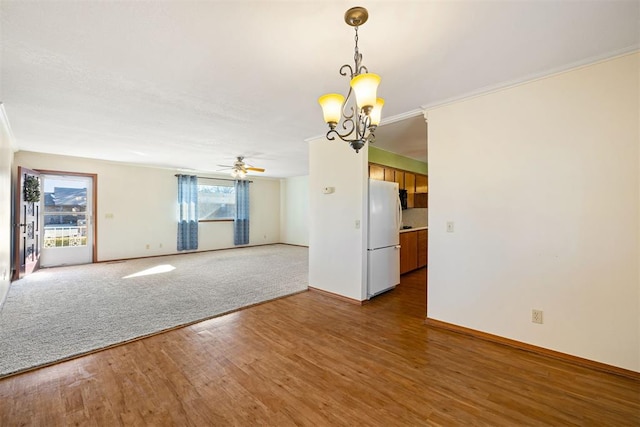 empty room with hardwood / wood-style flooring and ceiling fan with notable chandelier