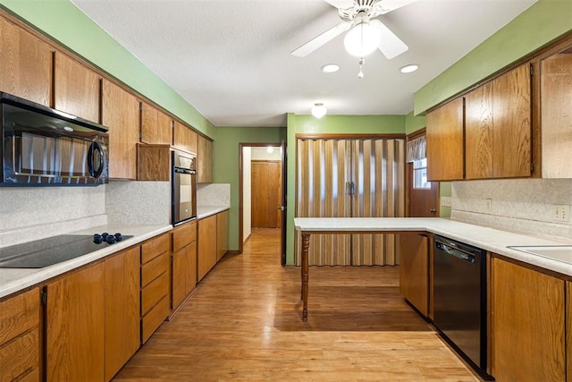 kitchen with sink, backsplash, ceiling fan, black appliances, and light hardwood / wood-style flooring