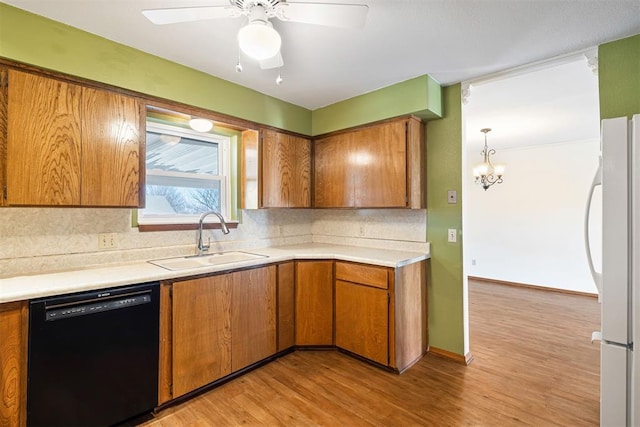 kitchen featuring sink, backsplash, black dishwasher, light hardwood / wood-style floors, and white fridge