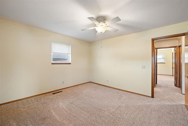 carpeted spare room with ceiling fan and a textured ceiling