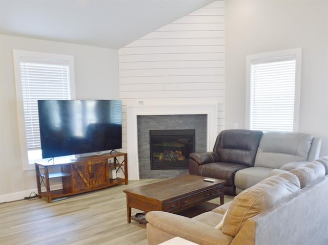 living room featuring vaulted ceiling, a healthy amount of sunlight, and light wood-type flooring