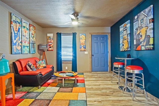 recreation room featuring light wood-style flooring, baseboards, and ceiling fan