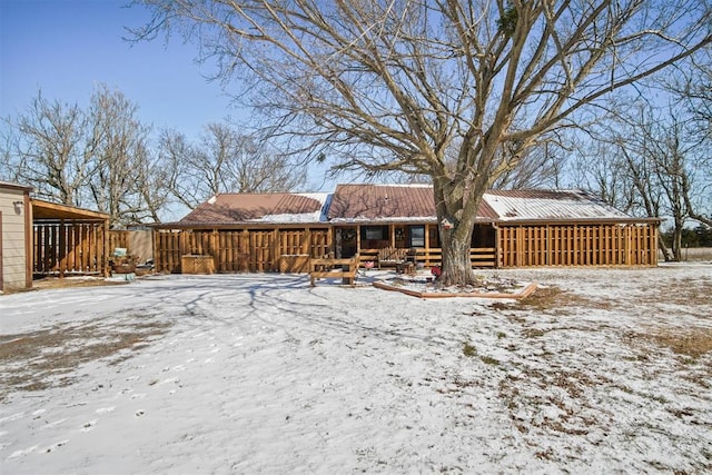 snow covered house featuring metal roof