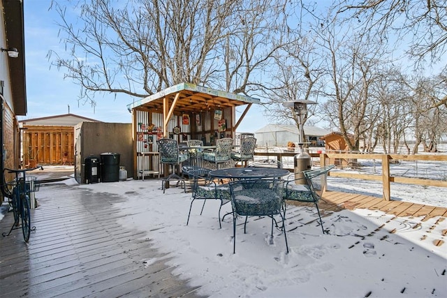 snow covered deck featuring outdoor dining area