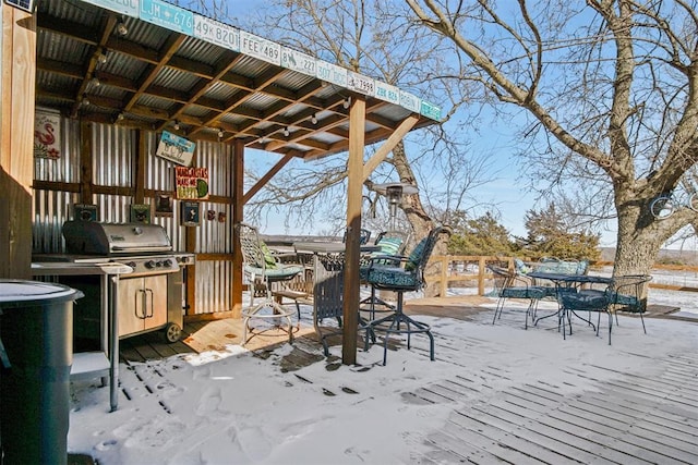 snow covered patio featuring outdoor dining area and area for grilling