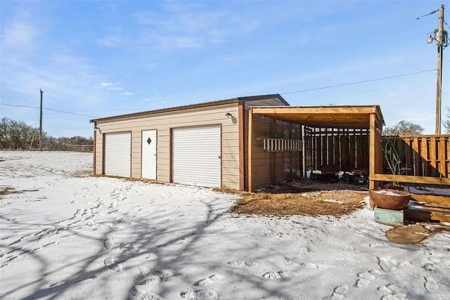 snow covered garage with a detached garage