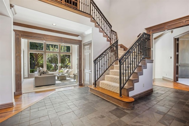 entrance foyer featuring crown molding and a towering ceiling