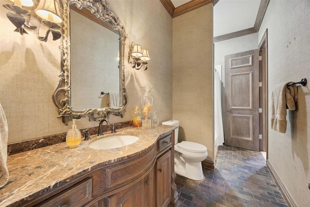 bathroom featuring toilet, vanity, and ornamental molding