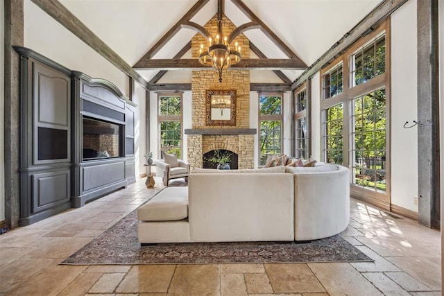 living room with high vaulted ceiling, beamed ceiling, a chandelier, and a stone fireplace