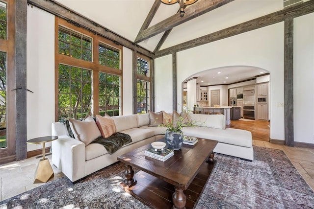 living room featuring high vaulted ceiling and beam ceiling