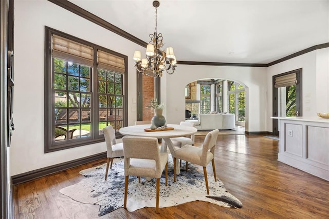 dining area featuring dark hardwood / wood-style flooring, crown molding, and an inviting chandelier