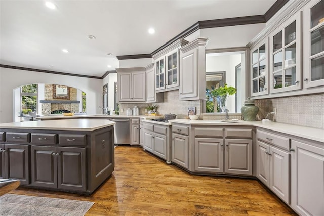 kitchen featuring appliances with stainless steel finishes, wood-type flooring, a kitchen island, and gray cabinetry