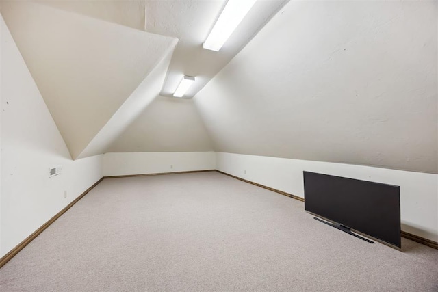 bonus room with carpet and vaulted ceiling