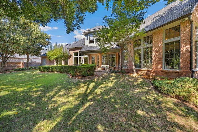 rear view of house featuring a lawn