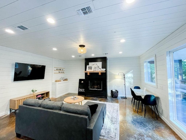 living room with a fireplace, visible vents, and recessed lighting