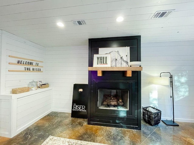 room details with visible vents, a fireplace, and wooden walls