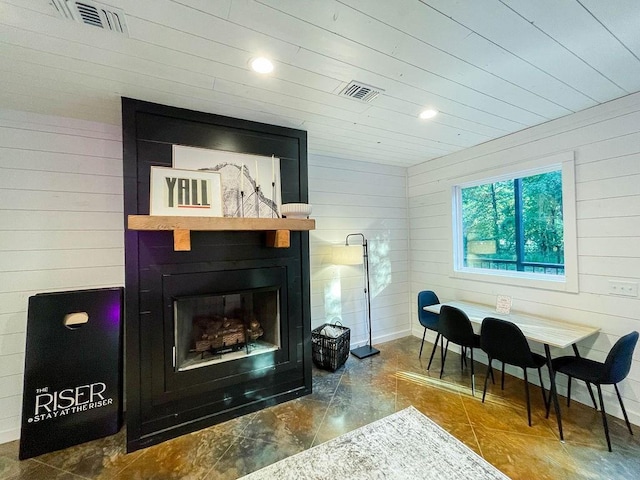 interior space with wood walls, a fireplace, and visible vents
