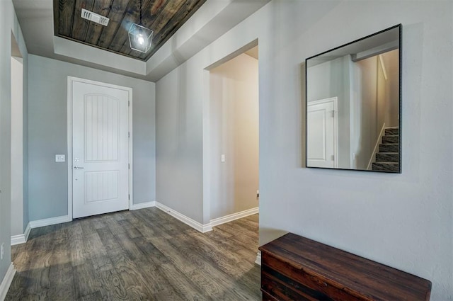 entrance foyer with a tray ceiling and dark wood-type flooring