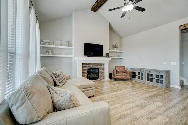 living room with a fireplace, ceiling fan, light wood-type flooring, and lofted ceiling with beams