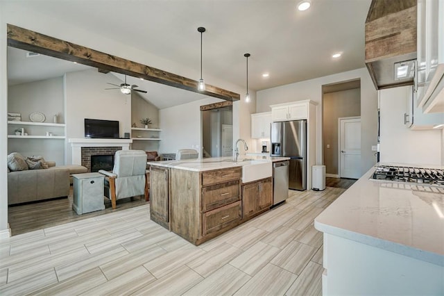 kitchen featuring white cabinetry, light stone counters, appliances with stainless steel finishes, and decorative light fixtures